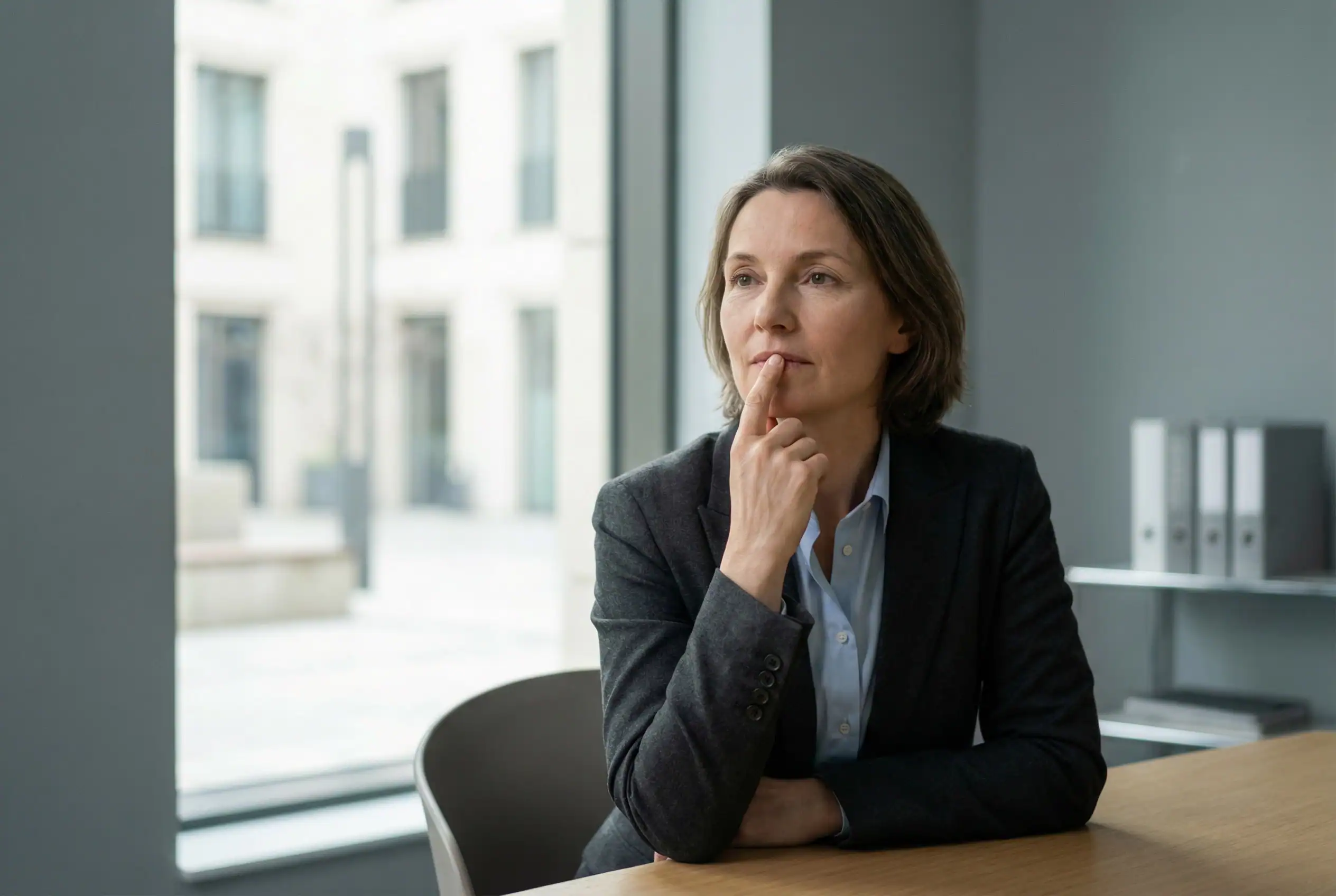 Professionnelle en situation de réflexion illustrant le silence des équipes comme signal organisationnel avant un plan de sauvegarde de l’emploi