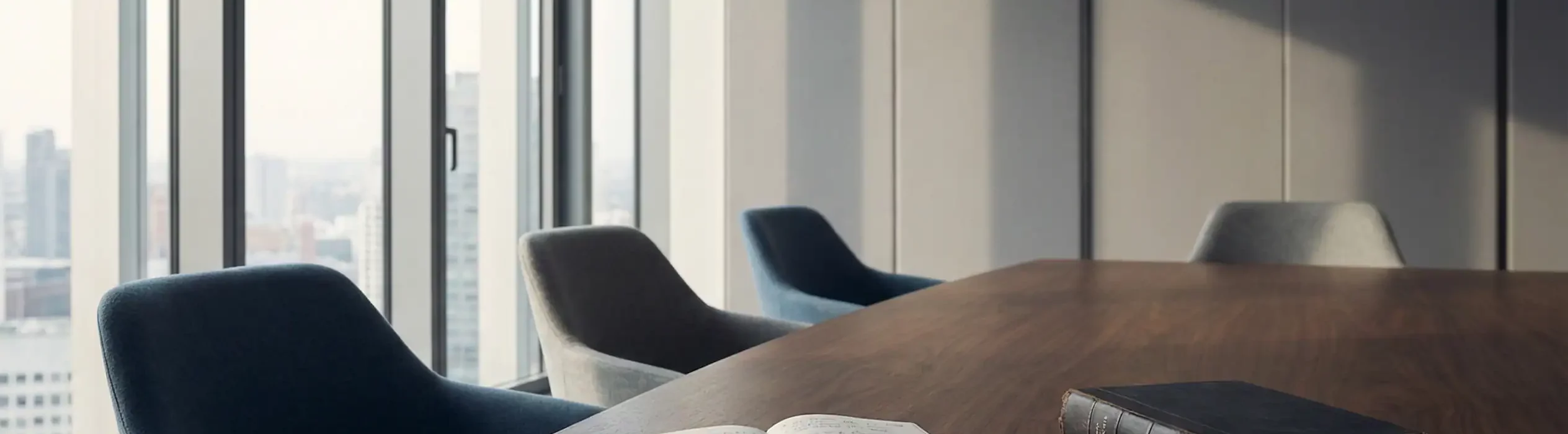 Salle de réunion d’entreprise vide, table en bois avec carnet ouvert et code juridique, symbolisant la responsabilité de l’employeur et la prévention des risques au travail.