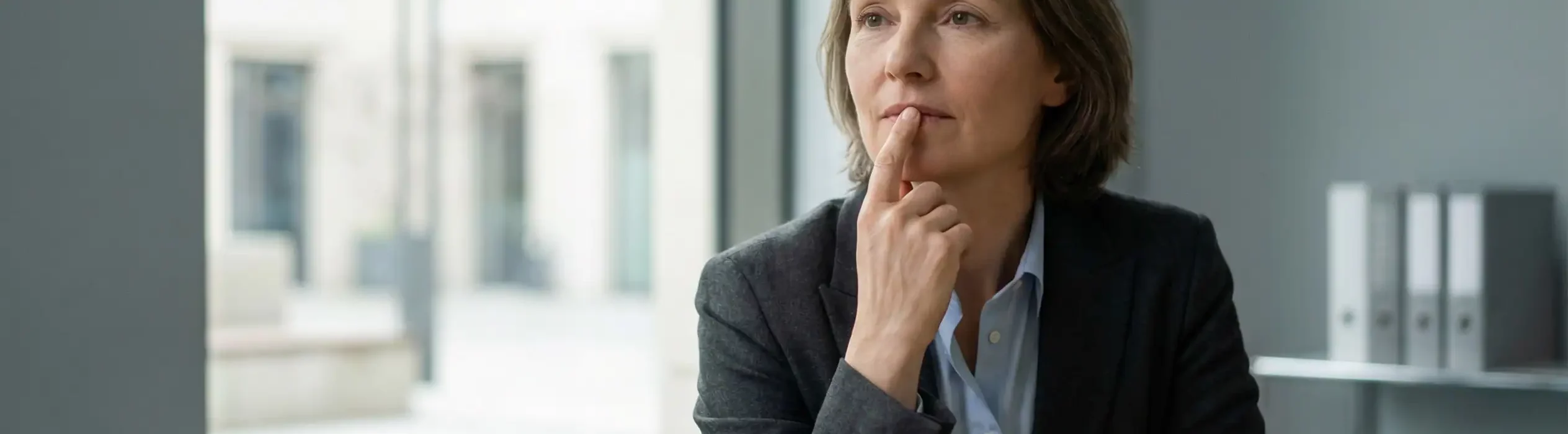 Professionnelle en situation de réflexion illustrant le silence des équipes comme signal organisationnel avant un plan de sauvegarde de l’emploi